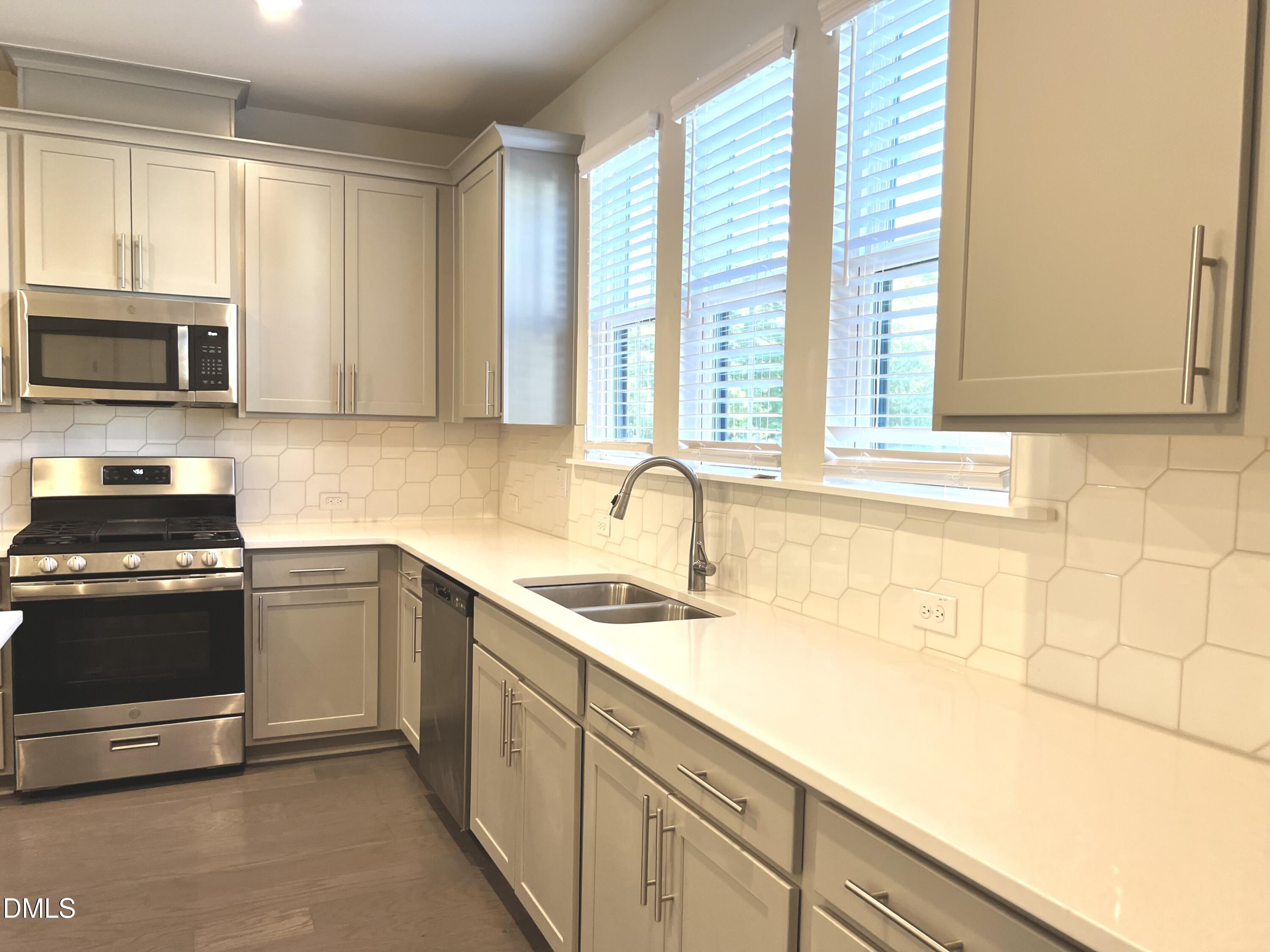 906 Waterside View Drive Raleigh, NC 27606 - Photo 8 of 9 a kitchen with stainless steel appliances granite countertop a sink and a stove