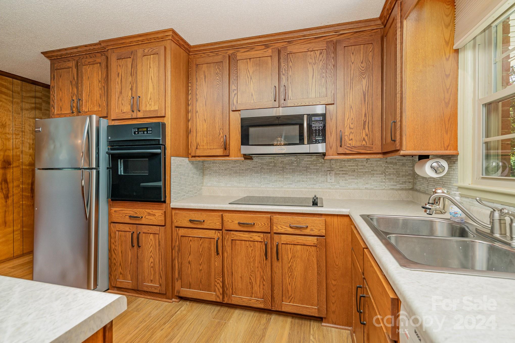 5124 Margaret Wallace Road Matthews, NC 28105 - Photo 11 of 26 a kitchen with stainless steel appliances granite countertop a refrigerator microwave and sink