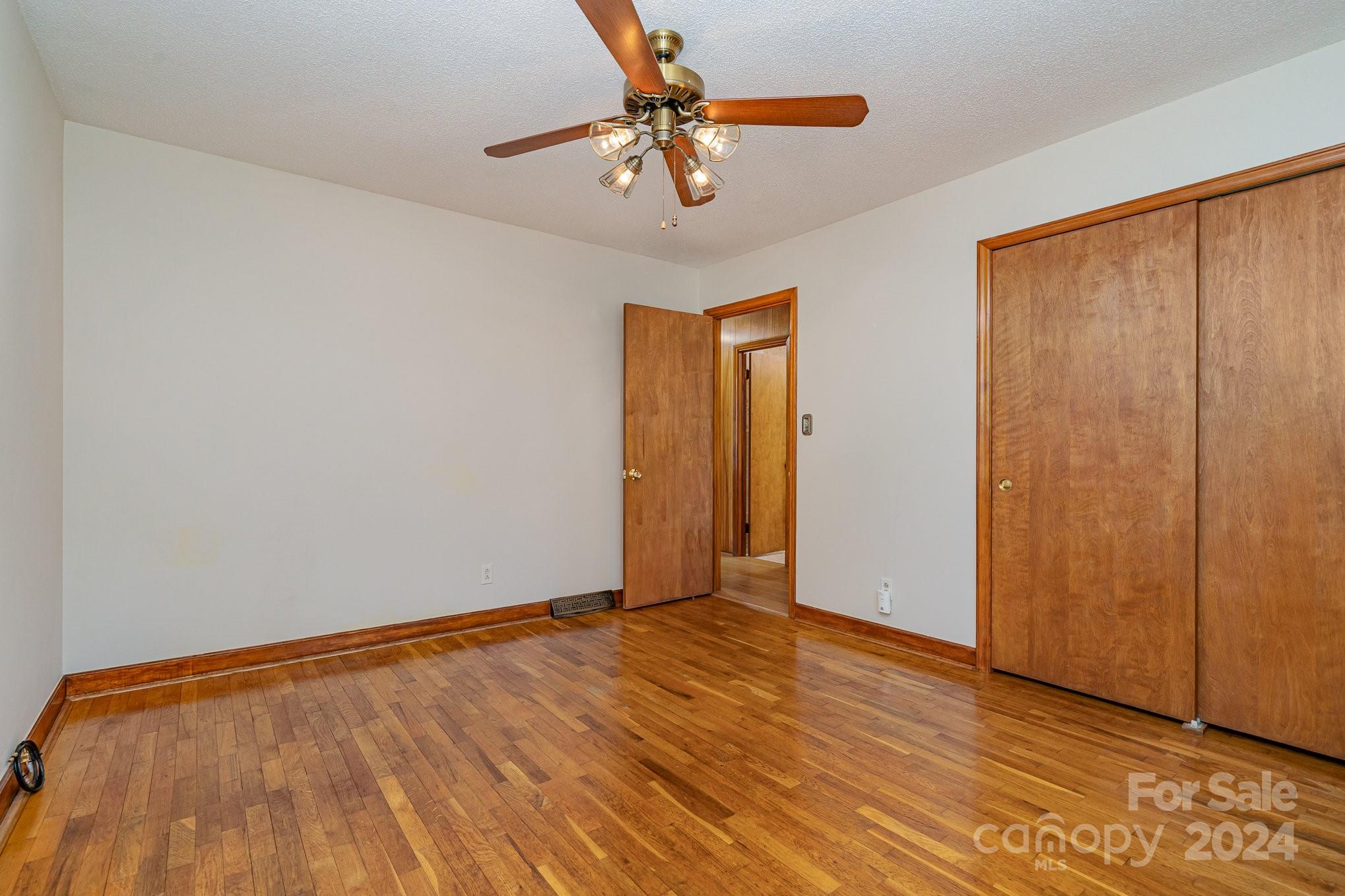 5124 Margaret Wallace Road Matthews, NC 28105 - Photo 13 of 26 a view of a room with wooden floor and a chandelier fan