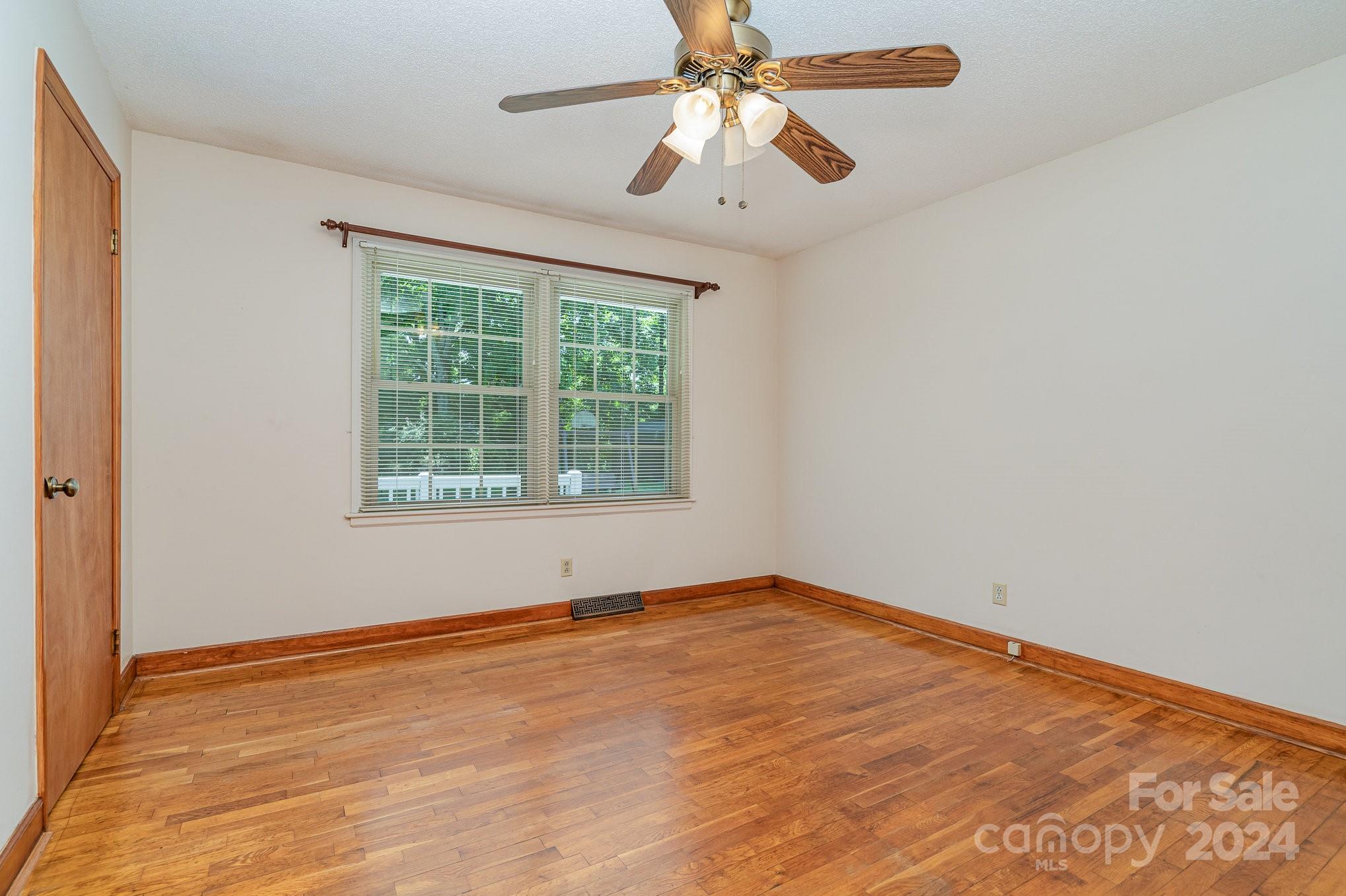 5124 Margaret Wallace Road Matthews, NC 28105 - Photo 17 of 26 an empty room with a window and a fan
