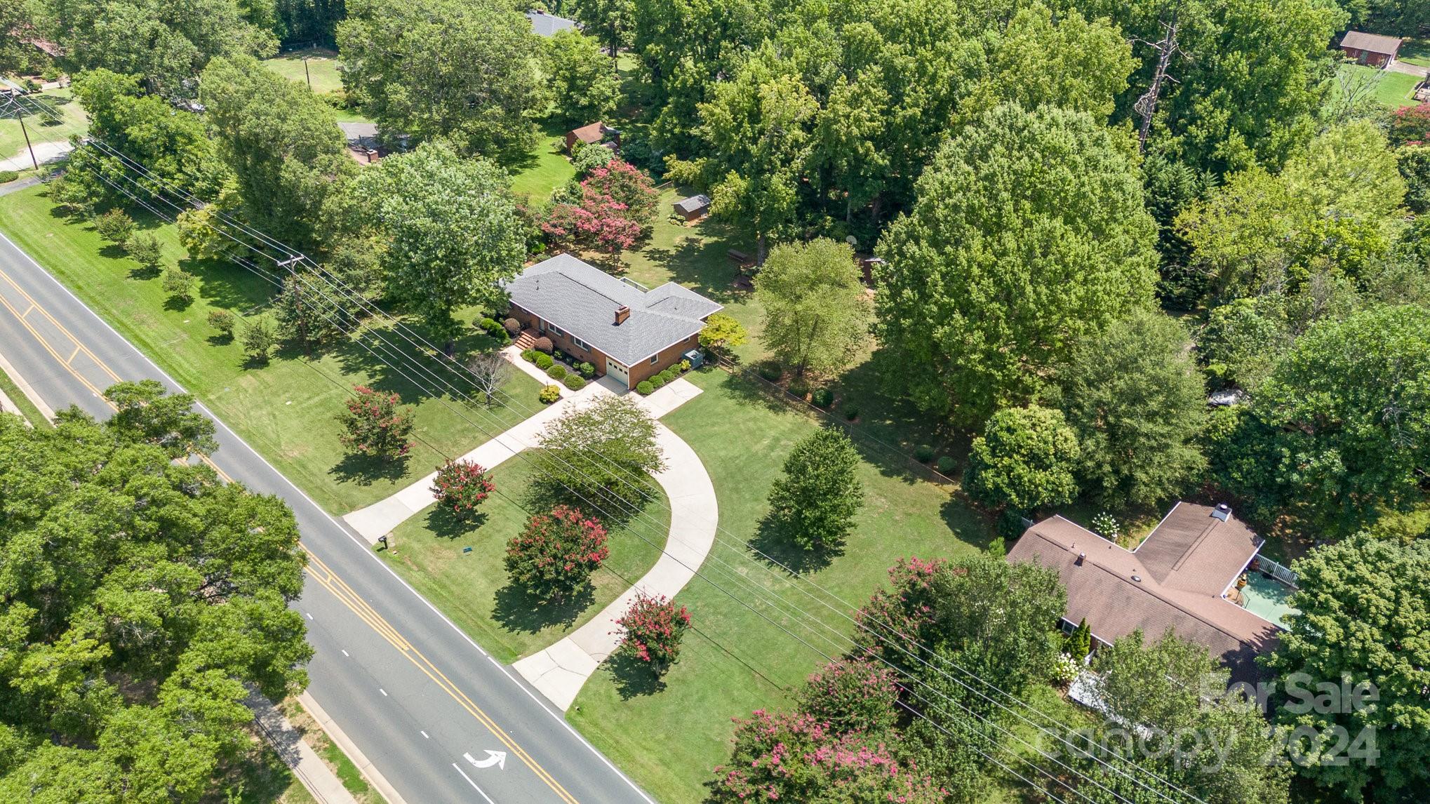 5124 Margaret Wallace Road Matthews, NC 28105 - Photo 2 of 26 an aerial view of a house with a yard and outdoor seating
