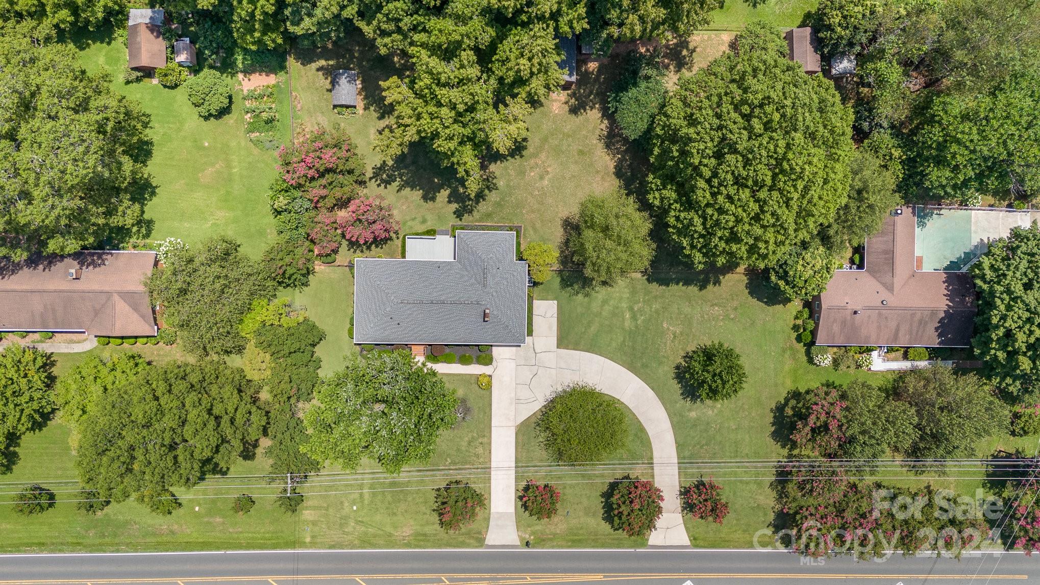 5124 Margaret Wallace Road Matthews, NC 28105 - Photo 26 of 26 an aerial view of a house with outdoor space and trees all around