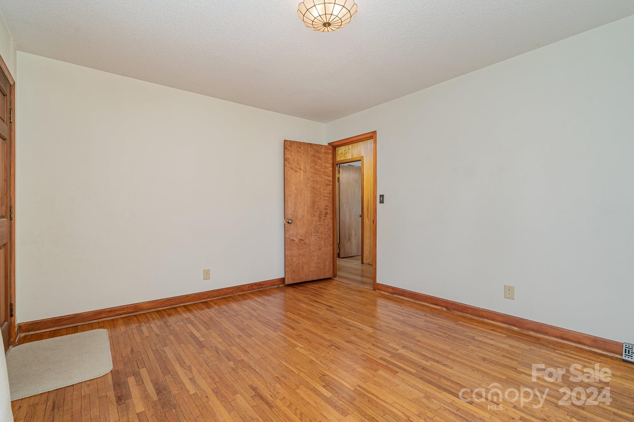 5124 Margaret Wallace Road Matthews, NC 28105 - Photo 5 of 26 a view of an empty room with wooden floor