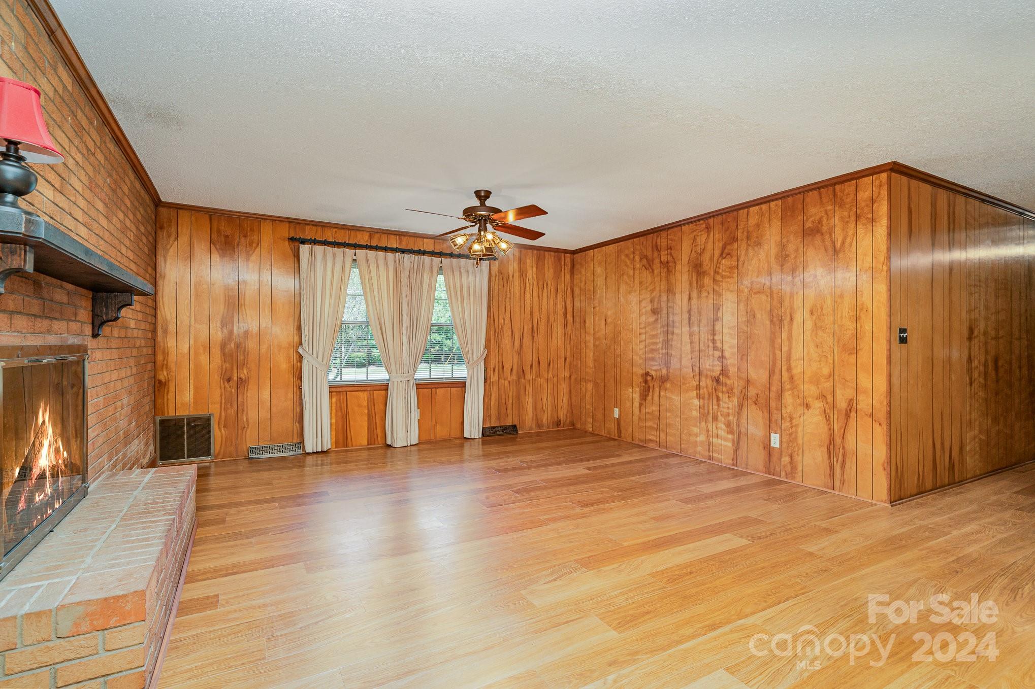 5124 Margaret Wallace Road Matthews, NC 28105 - Photo 7 of 26 a view of an empty room with wooden floor and a window