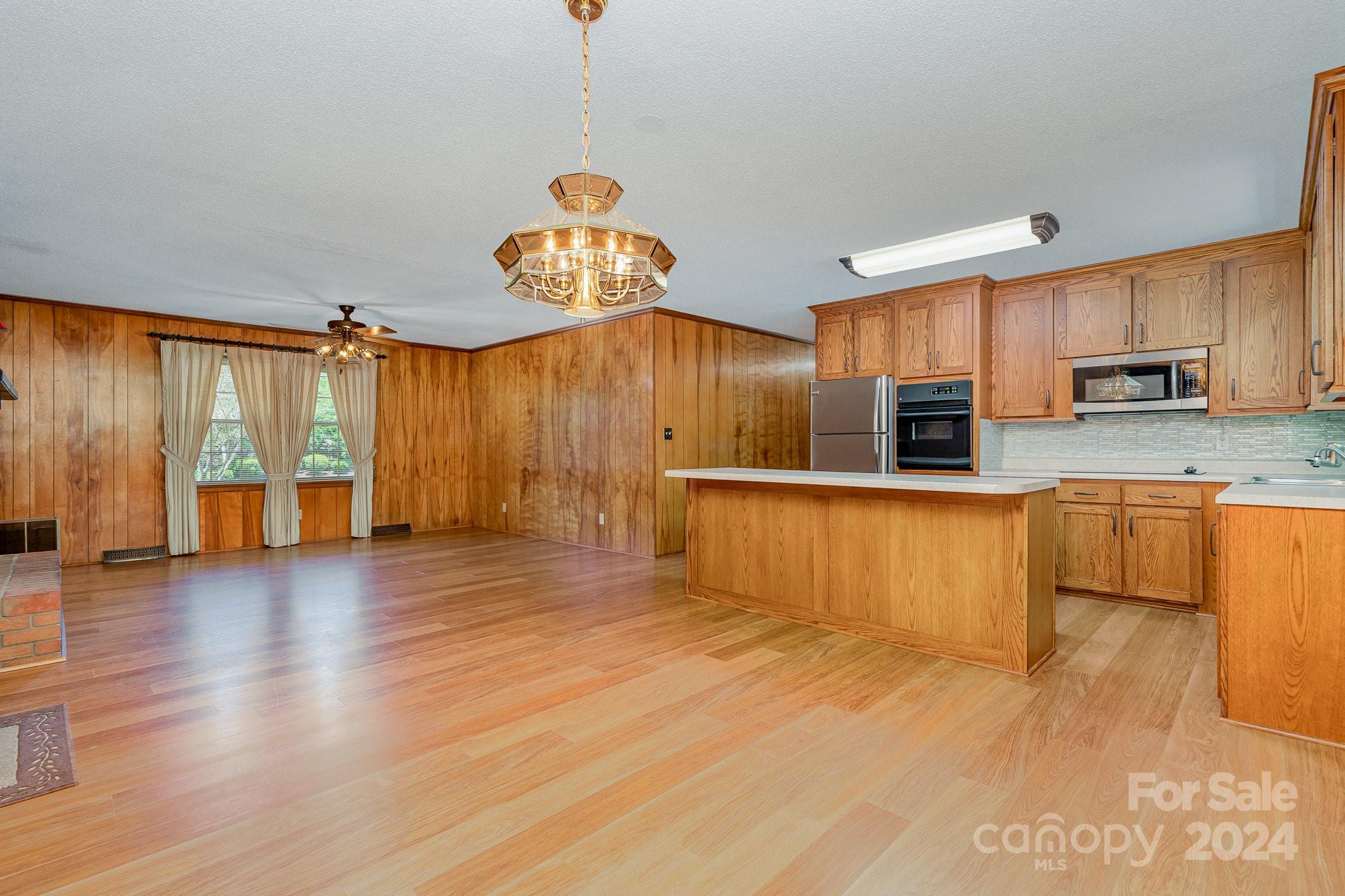 5124 Margaret Wallace Road Matthews, NC 28105 - Photo 8 of 26 a large kitchen with stainless steel appliances a large counter top a stove and a wooden floors