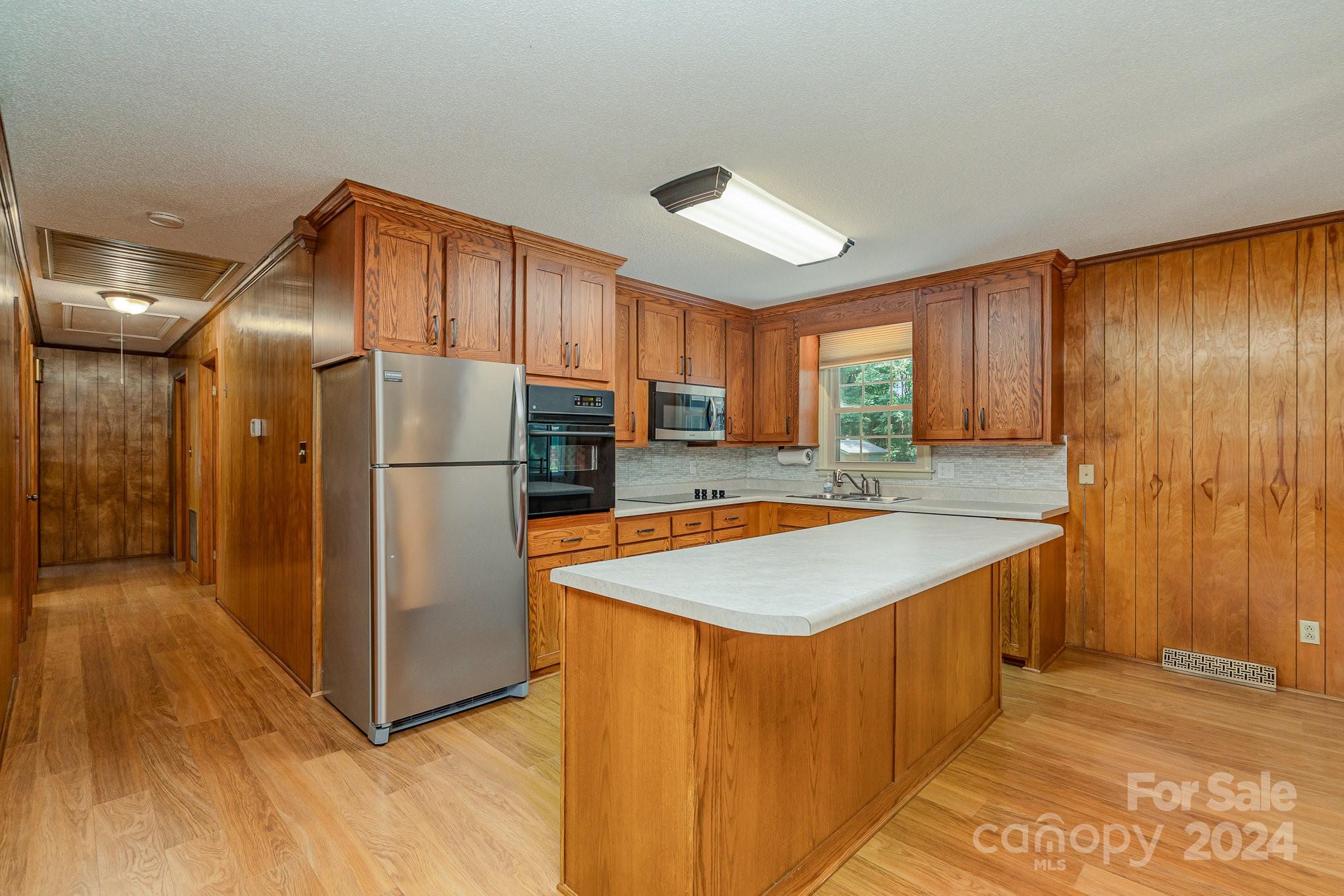 5124 Margaret Wallace Road Matthews, NC 28105 - Photo 9 of 26 a kitchen with stainless steel appliances granite countertop a refrigerator and a sink
