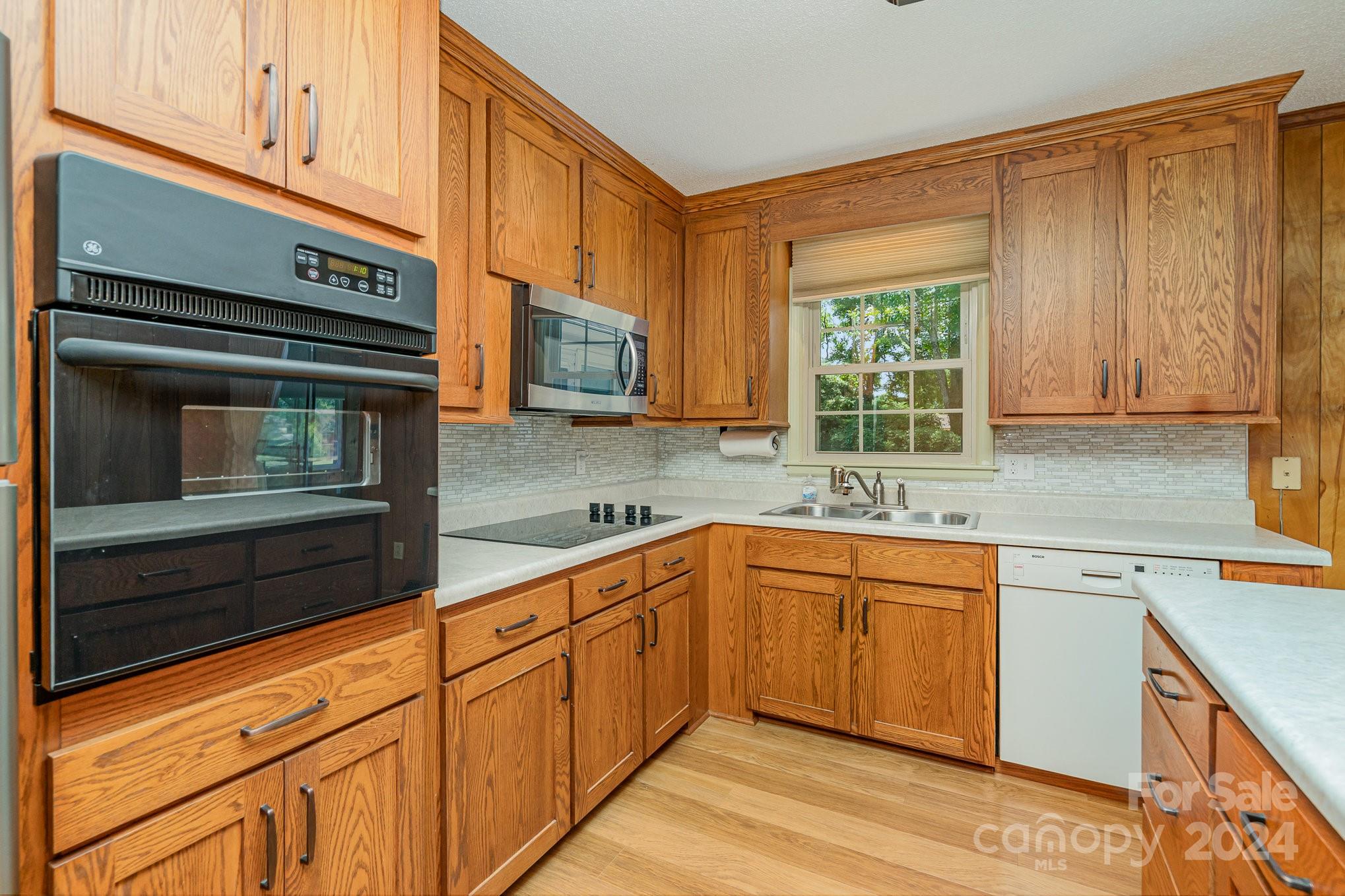 5124 Margaret Wallace Road Matthews, NC 28105 - Photo 10 of 26 a kitchen with stainless steel appliances granite countertop white cabinets and window