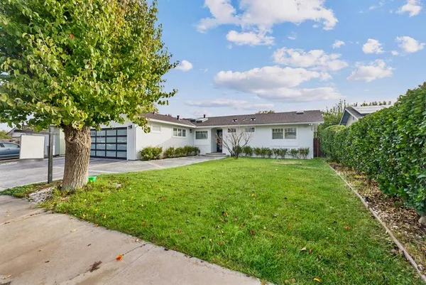 a view of a house with backyard and garden