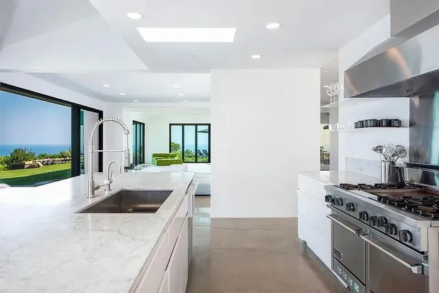 a kitchen with stainless steel appliances granite countertop a sink stove and refrigerator