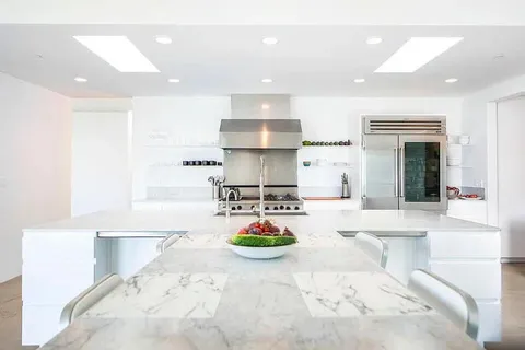 a kitchen with stainless steel appliances kitchen island granite countertop a sink and a stove