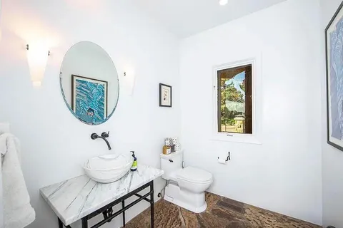 a bathroom with a toilet a sink and a mirror