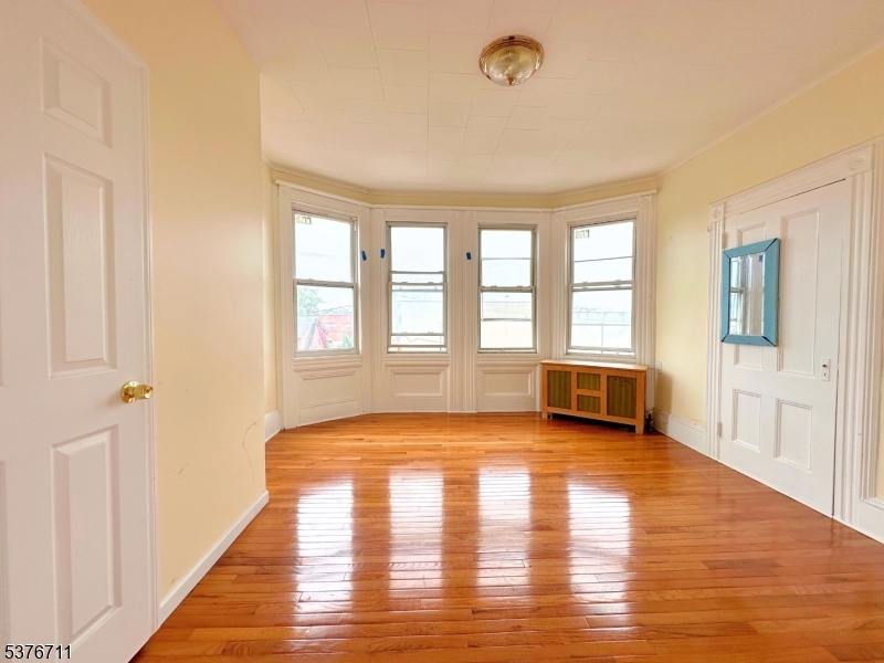 182 Knickerbocker Avenue, Unit 2 Paterson, NJ 07503 - Photo 13 of 14 a view of an empty room with window and wooden floor