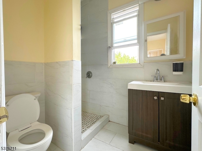 182 Knickerbocker Avenue, Unit 2 Paterson, NJ 07503 - Photo 6 of 14 a bathroom with a sink a toilet and shower
