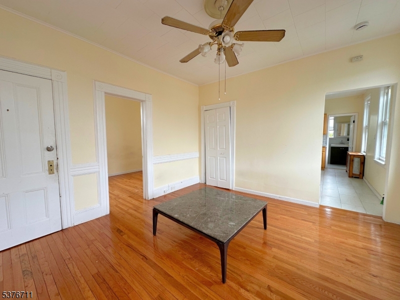 182 Knickerbocker Avenue, Unit 2 Paterson, NJ 07503 - Photo 9 of 14 a view of a room with wooden floor and a ceiling fan