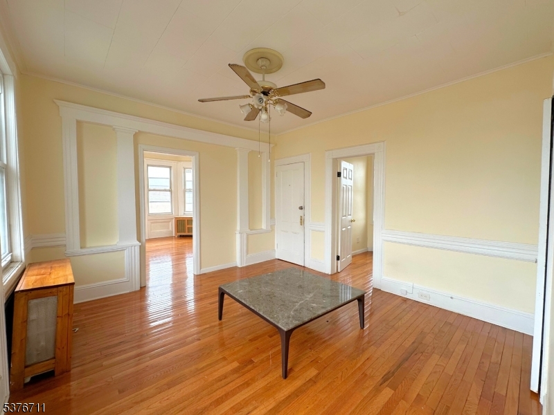 182 Knickerbocker Avenue, Unit 2 Paterson, NJ 07503 - Photo 10 of 14 a view of a livingroom with a hardwood floor and a ceiling fan