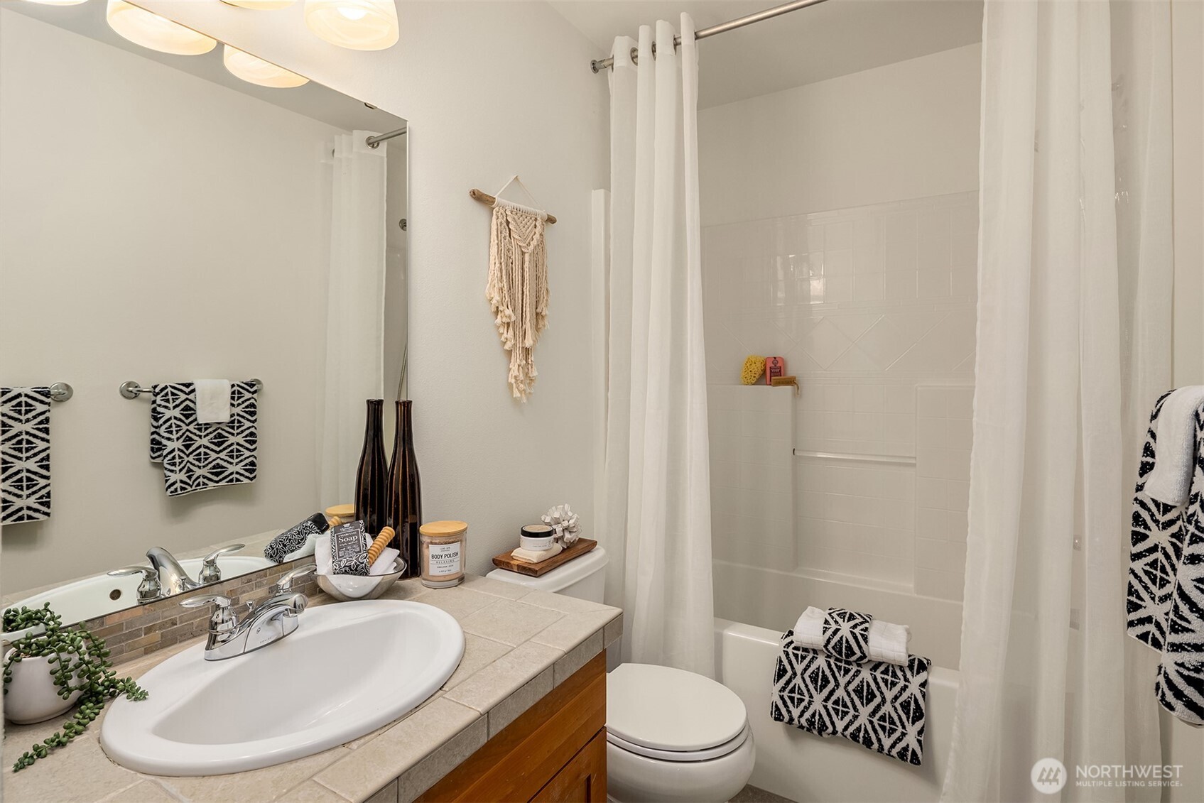 597 Alpine Ridge Place Northwest Issaquah, WA 98027 - Photo 27 of 32 a bathroom with a sink toilet a mirror and shower