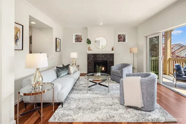 a living room with furniture a rug a fireplace and a large window