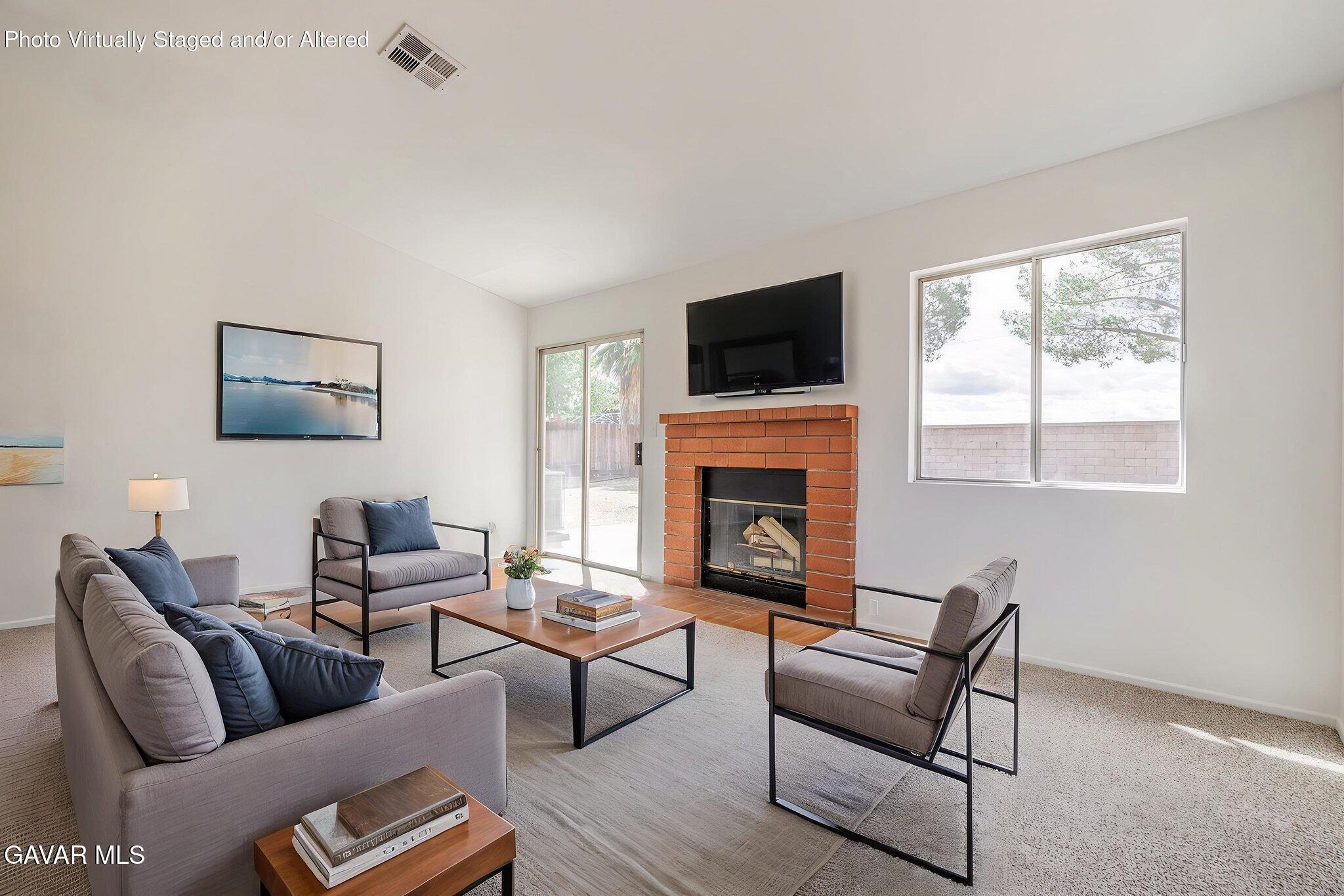 2340 Lightcap Street Lancaster, CA 93535 - Photo 15 of 40 a living room with furniture a fireplace and a flat screen tv