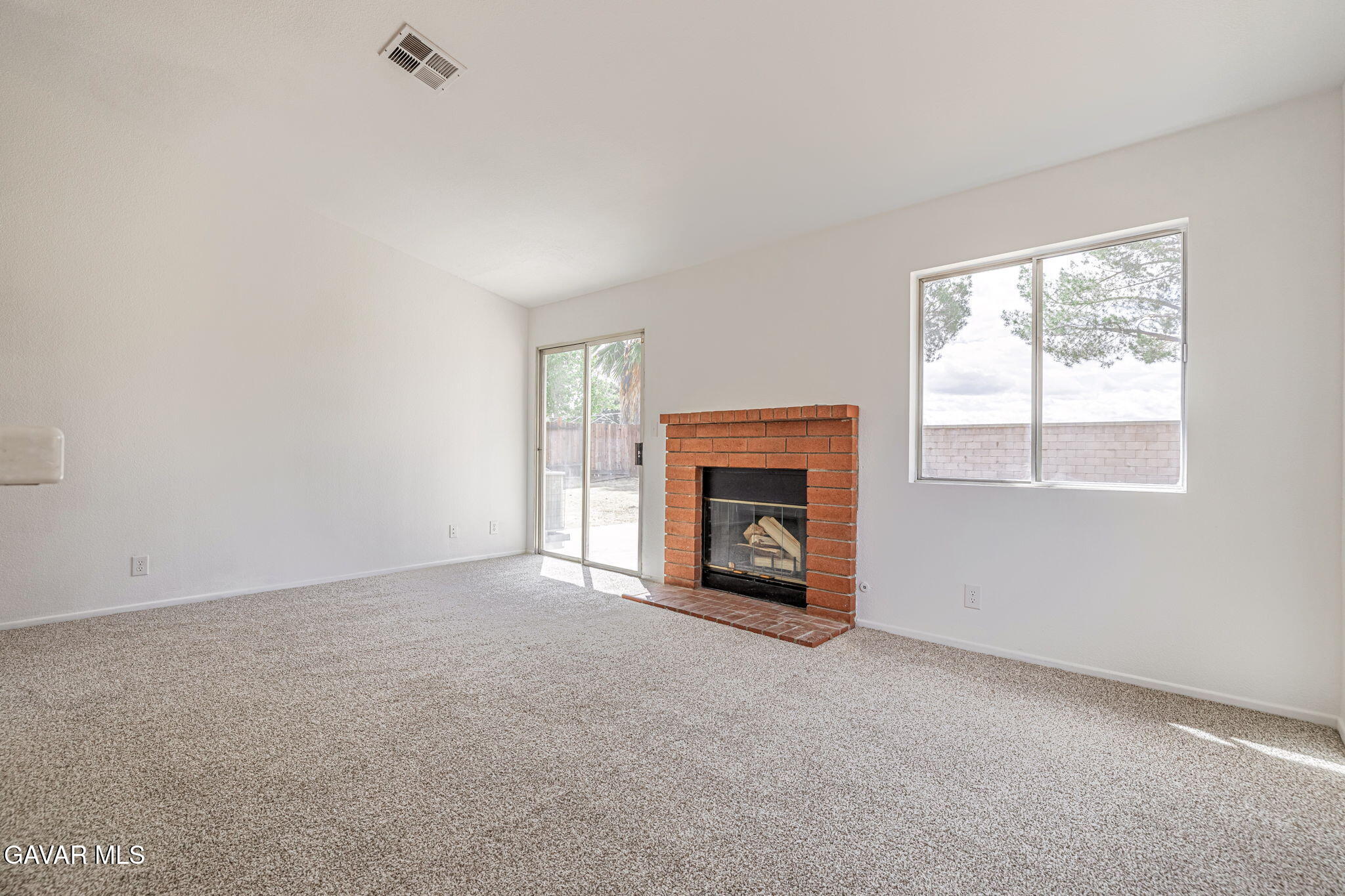 2340 Lightcap Street Lancaster, CA 93535 - Photo 16 of 40 an empty room with a fireplace and windows