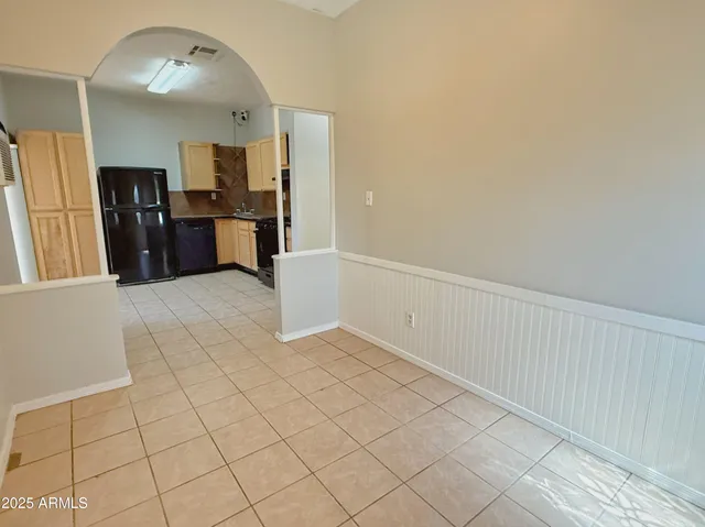 a view of a kitchen with refrigerator and white cabinets