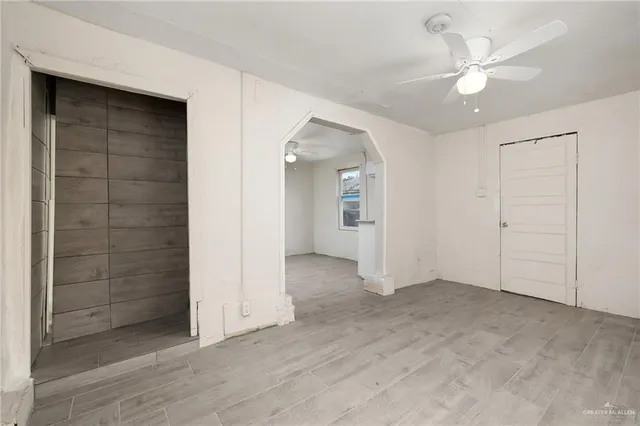an empty room with fan and entryway
