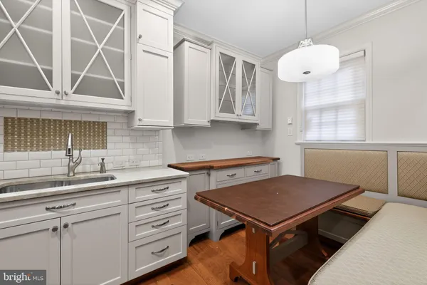 a kitchen with a stove a sink cabinets and a window
