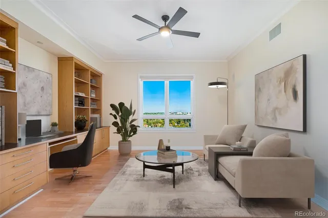 a living room with furniture a window and a potted plant