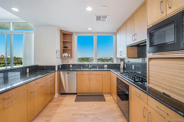 a large kitchen with stainless steel appliances granite countertop a sink stove and cabinets