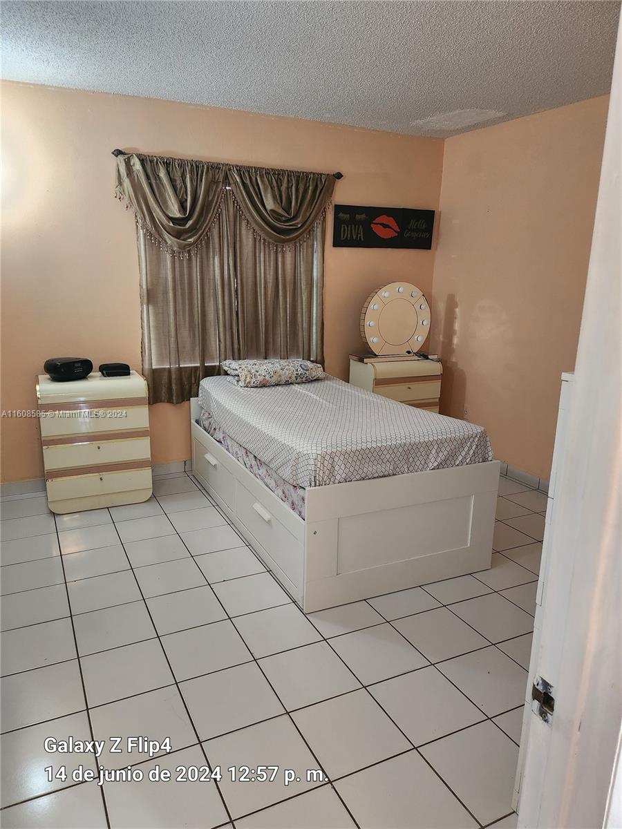 820 Southwest 105th Avenue, Unit 607 Miami, FL 33174 - Photo 14 of 22 a bedroom with a bed and painting on the wall