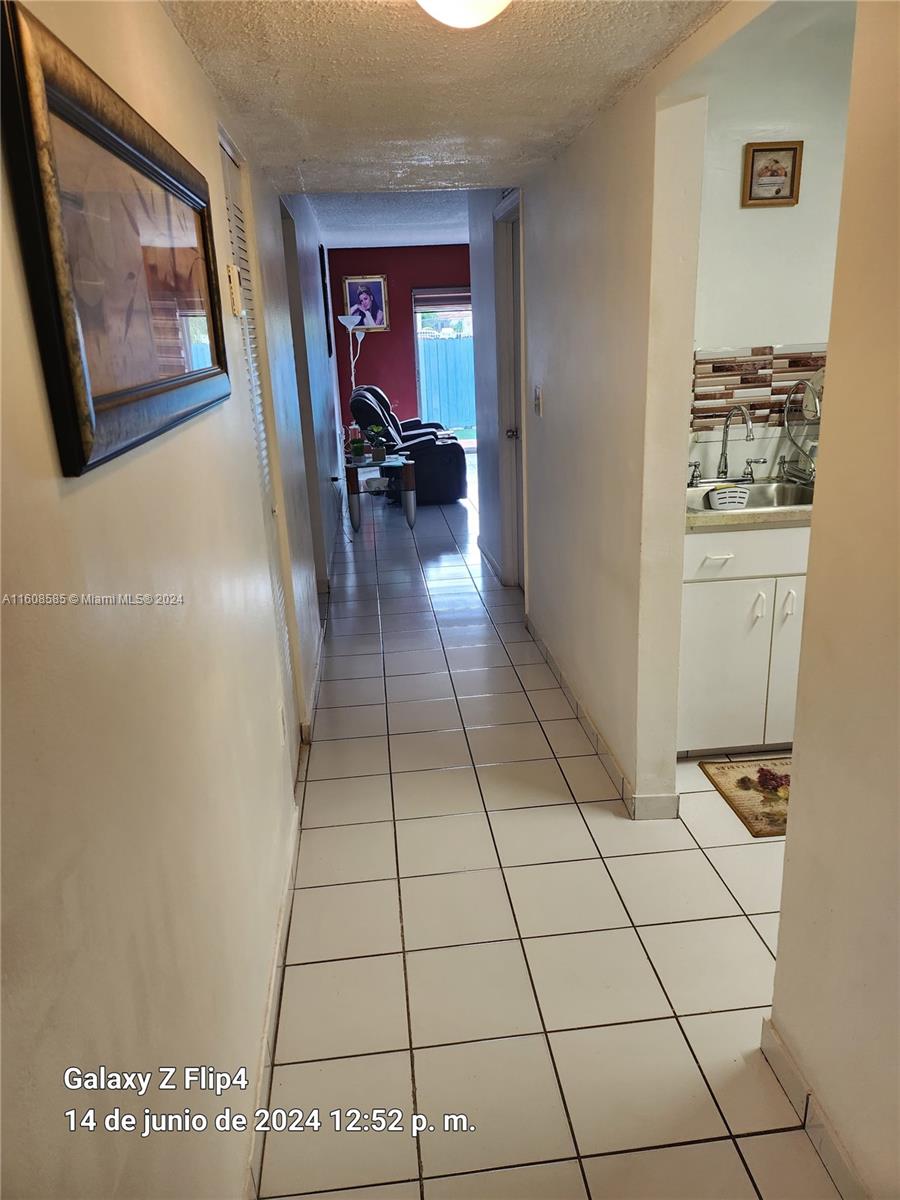 820 Southwest 105th Avenue, Unit 607 Miami, FL 33174 - Photo 4 of 22 a view of a hallway with wooden floor and furniture
