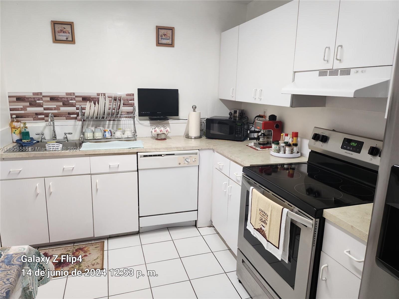 820 Southwest 105th Avenue, Unit 607 Miami, FL 33174 - Photo 5 of 22 a kitchen with a sink cabinets and appliances
