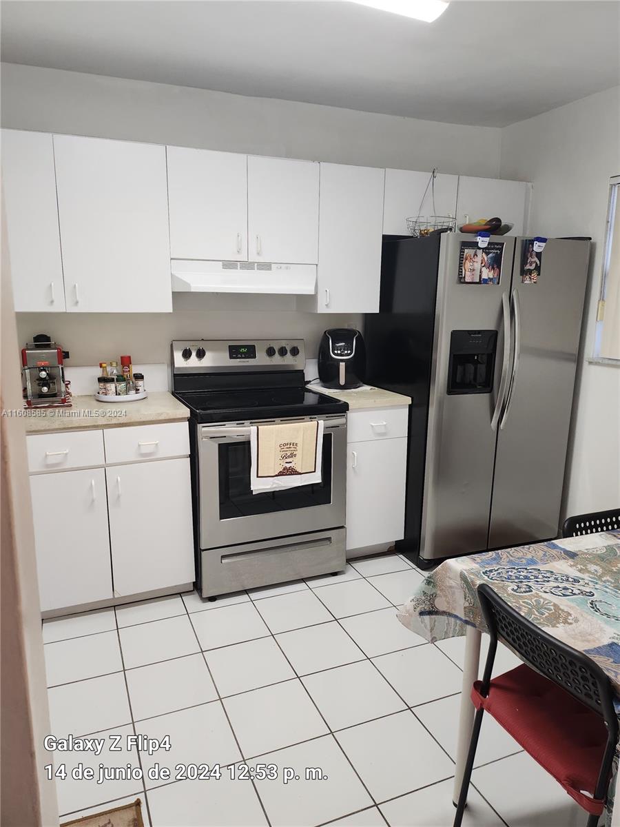 820 Southwest 105th Avenue, Unit 607 Miami, FL 33174 - Photo 6 of 22 a kitchen with a stove a refrigerator and cabinets