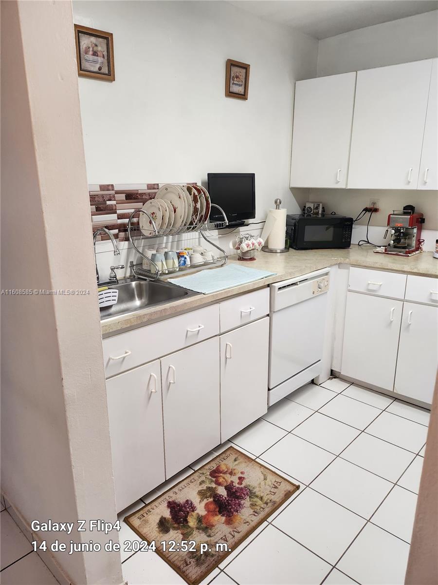 820 Southwest 105th Avenue, Unit 607 Miami, FL 33174 - Photo 7 of 22 a kitchen with white cabinets a sink and white appliances