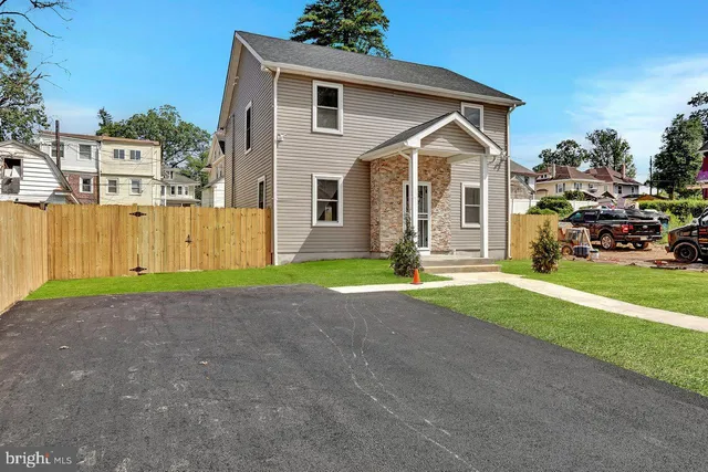 a front view of a house with a yard and lake view