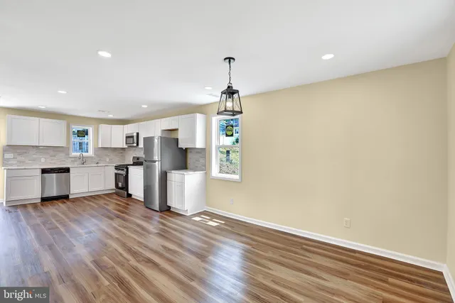a view of a room with wooden floor and windows