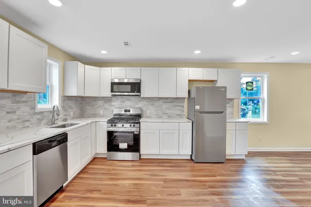 a kitchen with a refrigerator stove top oven and sink