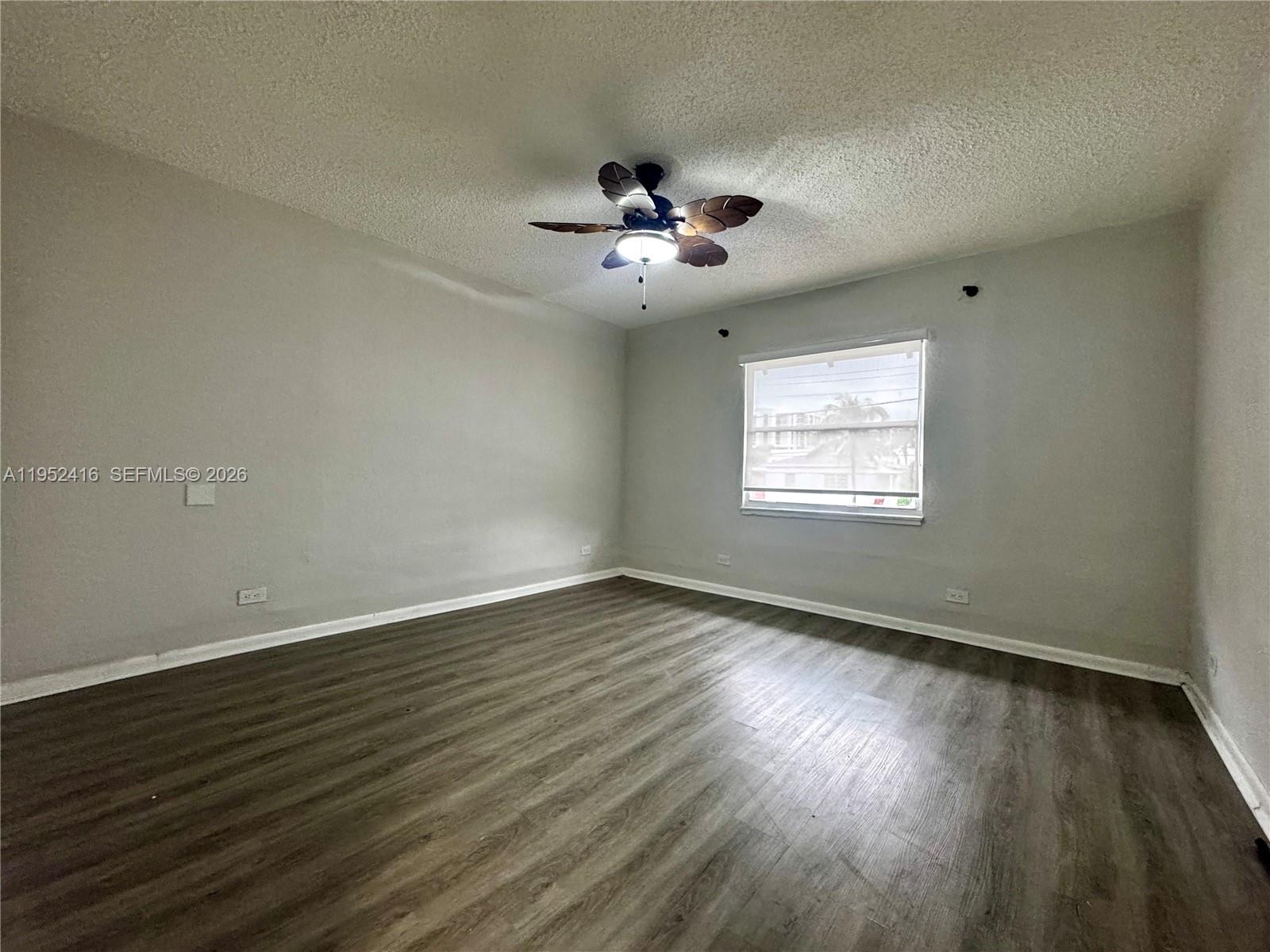 529 Southwest 3rd Street Miami, FL 33130 - Photo 9 of 12 a view of an empty room with wooden floor and a window