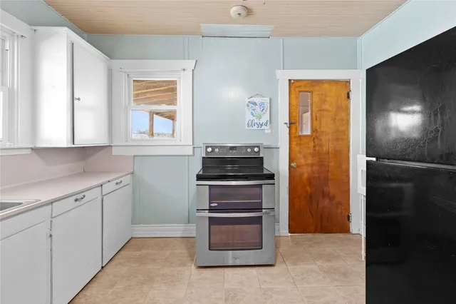 a view of an empty room with a window and a chandelier fan
