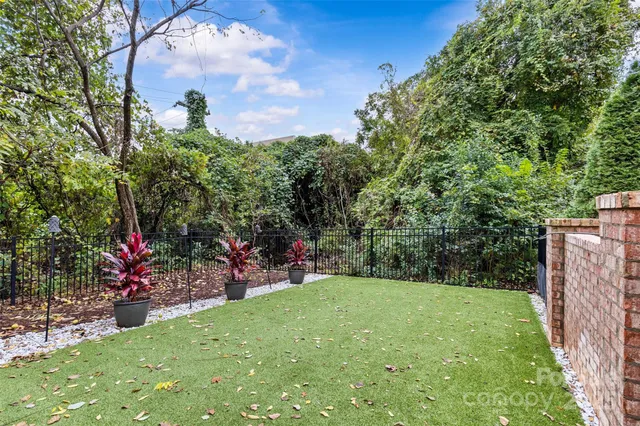 a front view of a building with large trees