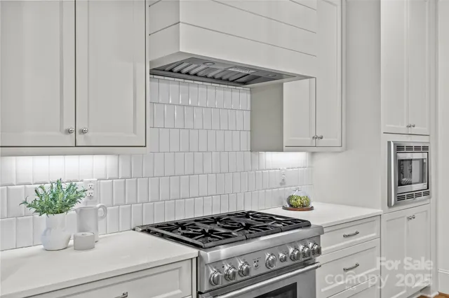 a kitchen with white cabinets and a stove