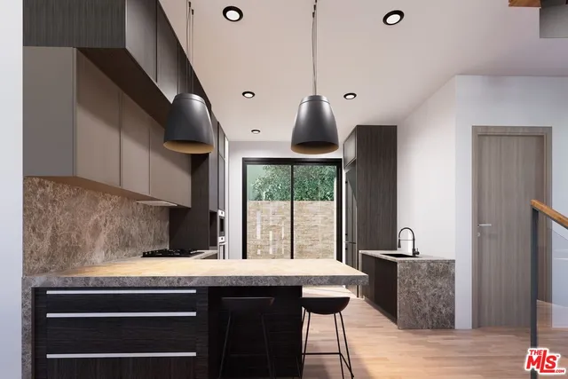 a kitchen with stainless steel appliances granite countertop a sink a stove a refrigerator and cabinets