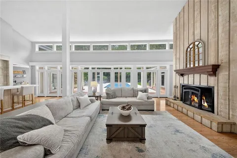 a living room with furniture large window and a fireplace