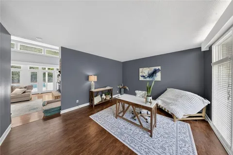 a bedroom with a bed ceiling fan and a wooden floor