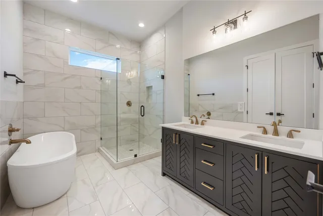a spacious bathroom with a double vanity sink mirror and bathtub