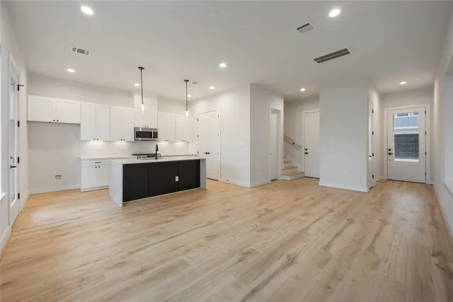 a large kitchen with stainless steel appliances granite countertop a large counter top a stove and a refrigerator