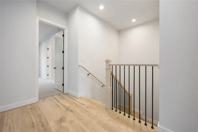 a view of a hallway with wooden floor and staircase