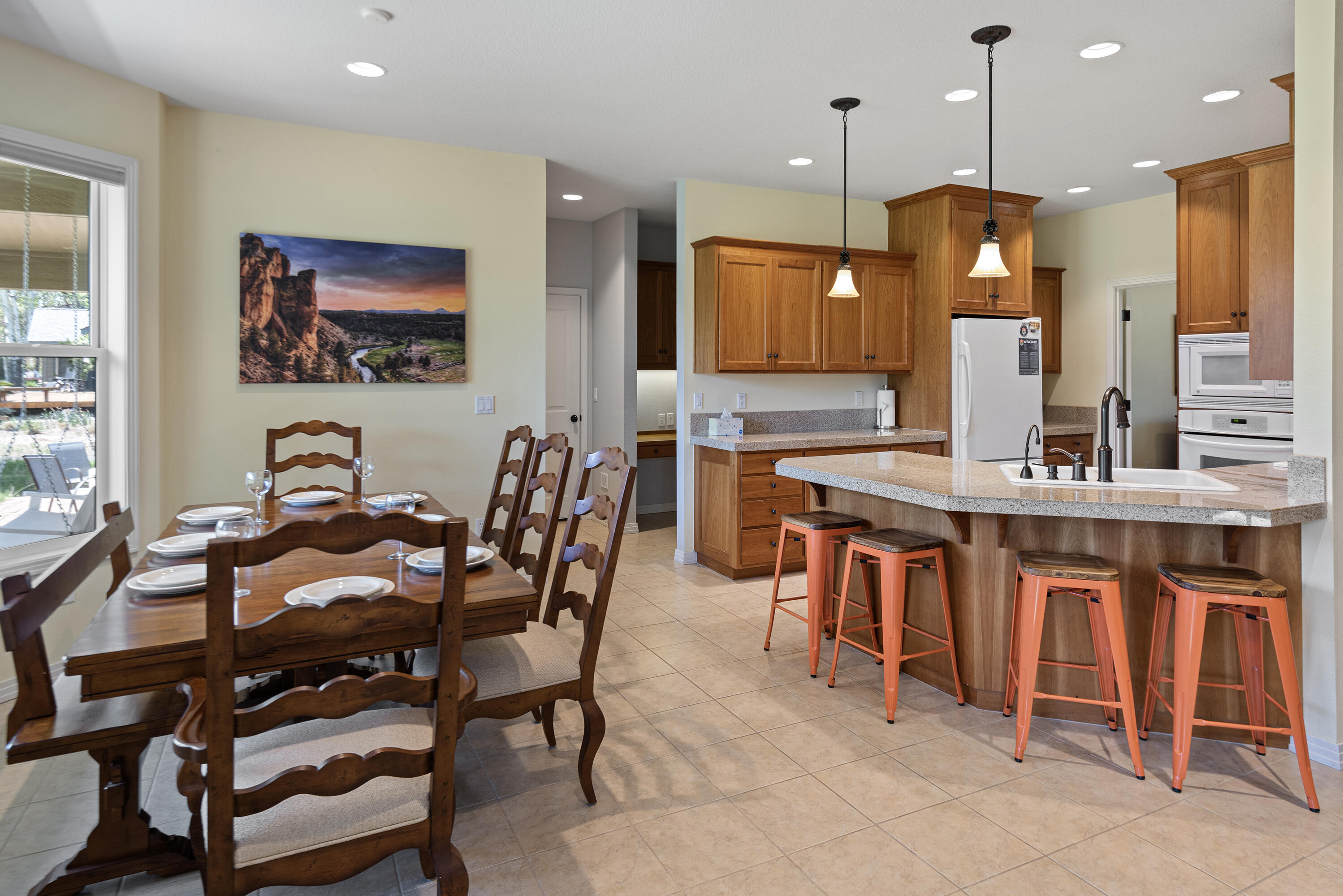 16775 Pony Express Way Bend, OR 97707 - Photo 7 of 38 a kitchen with a dining table chairs and white cabinets