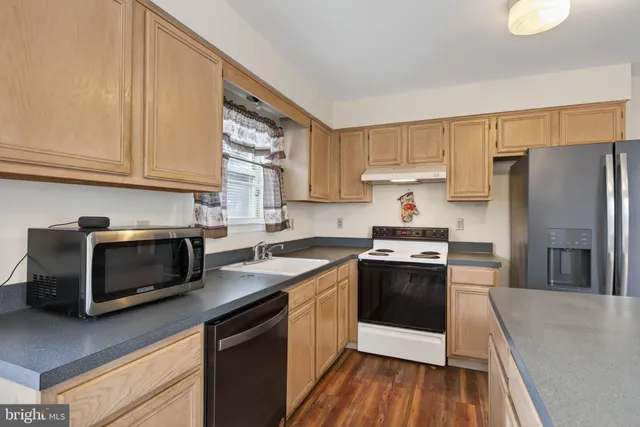 a kitchen with stainless steel appliances granite countertop a stove a sink and a refrigerator
