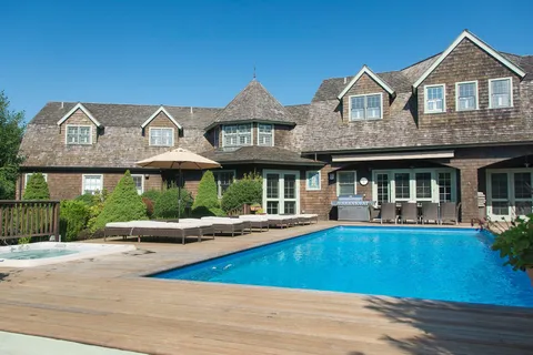 a view of a house with sitting area and swimming pool
