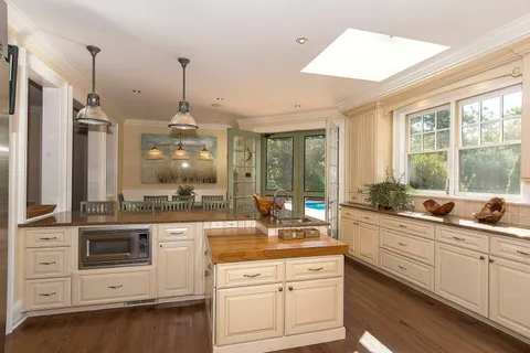 a open kitchen with stainless steel appliances white cabinets and a chandelier